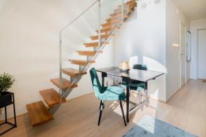 a dining room with a table and chairs and a staircase at Nordic Host - Tollbugata 13 in Oslo