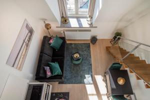 einen Blick über ein Wohnzimmer mit Sofa und Treppe in der Unterkunft Nordic Host - Tollbugata 13 in Oslo