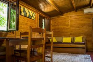 a dining room with a bench in a cabin at xisto camping in Janeiro de Baixo