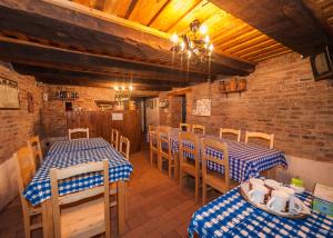 a restaurant with two tables and chairs and a brick wall at Pension Cartref in Saschiz
