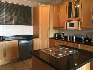 a kitchen with wooden cabinets and a black counter top at C-Rus in Strand