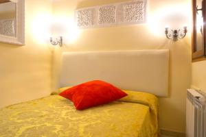 ein Zimmer mit einem Bett mit einem roten Kissen darauf in der Unterkunft Otto House Apartment in Venedig