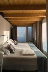 Cama grande en habitación con ventana en Apartamentos La Santilar, en Llanes