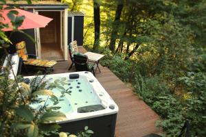a hot tub sitting on a wooden deck with a patio at Ferienhaus Refugium in Sessenbach