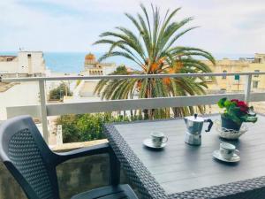 un tavolo su un balcone con vista sull'oceano di Casa BELLAVISTA tra MARE e TERME a Santa Cesarea Terme