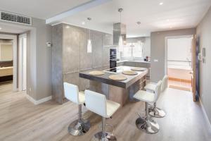 a kitchen with a island with white bar stools at Fantastic Apartment Next To Guadalmina Golf Course In Marbella in Marbella