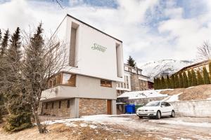 a white car parked in front of a building at Apartment SnowWhite in Starý Smokovec