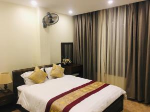 a bedroom with a bed and a window with curtains at Hoang Ngoc Hotel in Dồng Văn