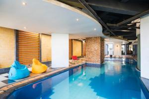 a swimming pool with blue water in a building at The Gloria Suites Grogol in Jakarta