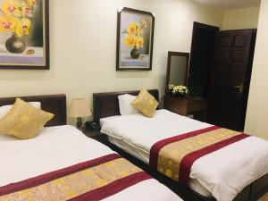 2 letti in una camera d'albergo con 2 letti sidx sidx di Hoang Ngoc Hotel a Đồng Văn