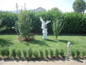 a statue in the grass in a garden at Guest House Regina Mundi in Međugorje