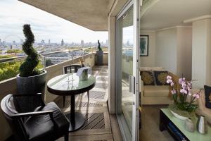 a room with a balcony with a table and a couch at The Cavendish London in London