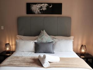 a bed with two towels on it with two lamps at Goedehoop Boutique Manor House in Malelane +59 photos