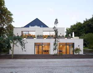 a white house with a black roof at Haus Rissen Gaestehaus in Hamburg