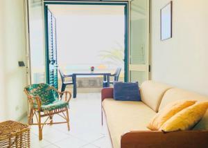 ein Wohnzimmer mit einem Sofa und einem Stuhl in der Unterkunft Casa BELLAVISTA tra MARE e TERME in Santa Cesarea Terme