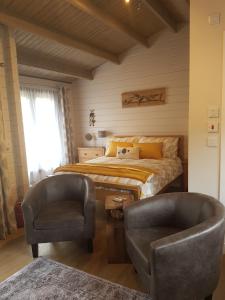 a bedroom with a bed and a pair of chairs at CROFTERS CABIN in Bracadale