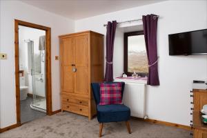 a living room with a chair and a window at Ceol na Mara Guest House in Tarbert