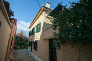 a building with green windows on the side of it at Tis Mammis in Nafplio