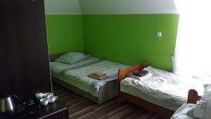 Habitación verde con 2 camas y espejo. en INEZ en Lelice