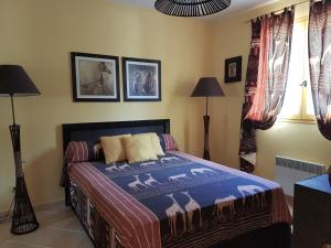 ein Schlafzimmer mit einem Bett mit einer blauen Decke darauf in der Unterkunft Residence U MELU GRAND T3 JAUNE à l'étage in Tiuccia