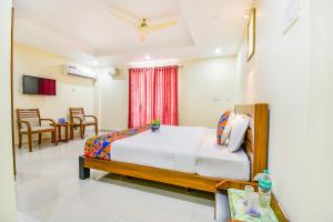 a bedroom with a bed, chair, and table in it at FabHotel Sri Krishna Residency Airport in Chennai