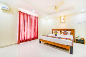 a bedroom with a bed and a dresser at FabHotel Sri Krishna Residency Airport in Chennai
