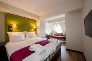 a hotel room with a large bed with towels on it at Three Corners Hotel Art in Budapest
