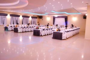 a large banquet hall with white tables with people sitting at them at INEZ in Lelice