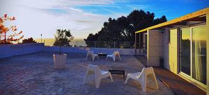 un grupo de sillas blancas y una mesa en un patio en Residencia Praia Norte - AL, en Nazaré