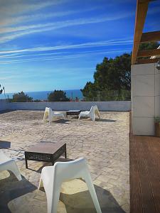 a group of white chairs and tables on a patio at Residencia Praia Norte - AL in Nazaré