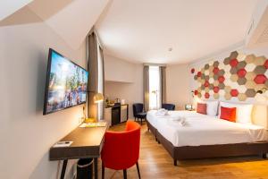 ブダペストにあるThree Corners Hotel Artのベッドと机とテレビがあるホテルの部屋 +90枚の写真
