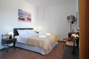 a hotel room with a bed and a tv at Kythera Golden Sun in Agia Pelagia