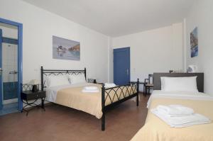 a bedroom with two beds and a blue door at Kythera Golden Sun in Agia Pelagia Kythira