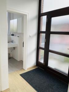 a bathroom with a glass door and a sink at Moderner Bungalow, 20 Minuten bis Hannover City, 24h Check-In in Garbsen