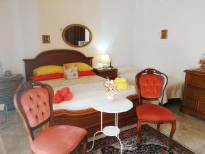 a bedroom with a bed with two chairs and a table at Amabile Guesthouse in Milis