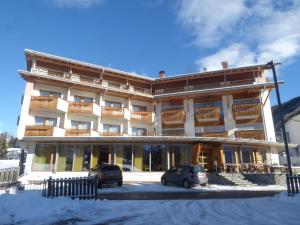 duży budynek z samochodami zaparkowanymi przed nim w obiekcie Sporthotel Rasen w mieście Rasun di Sotto