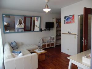 ein Wohnzimmer mit einem weißen Sofa und einem Spiegel in der Unterkunft Apartment Maritime in Bad Krozingen