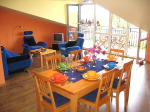 a dining room with a table and chairs and a room with at Nida Panorama in Nida