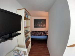 einen Flur mit einem Zimmer mit einem Bett und einem TV in der Unterkunft Apartment Maritime in Bad Krozingen