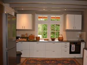 una cocina con armarios blancos y una ventana en Maison canadienne, en Salbris
