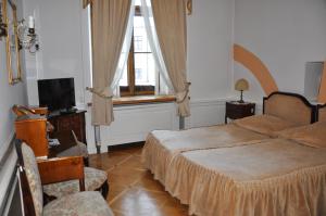 sypialnia z łóżkiem, telewizorem i oknem w obiekcie Hotel Zamek Pułtusk Dom Polonii w Pułtusku