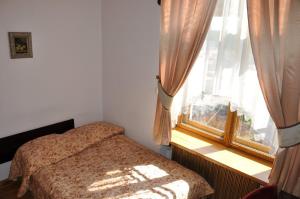 niewielka sypialnia z łóżkiem i oknem w obiekcie Hotel Zamek Pułtusk Dom Polonii w Pułtusku