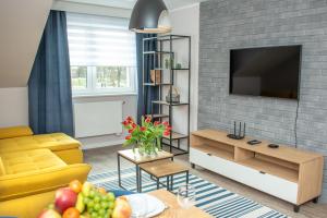 Televízia a/alebo spoločenská miestnosť v ubytovaní Apartamenty Leśna 1