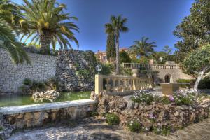 ベニッサにあるVilla Prestigeの池とヤシの木がある家