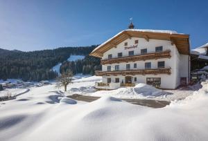 un grande edificio con neve sul terreno di fronte di Wanishof a Thiersee