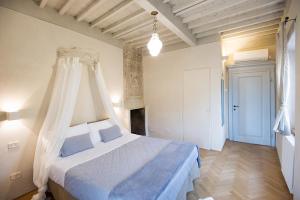 a bedroom with a white bed with a canopy at Il Piccolo Cavour Charming House B&B in Arezzo