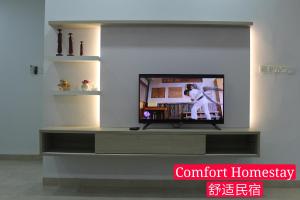 Muar Homestay (Comfort Homestay) في موار: تلفزيون في غرفة المعيشة مع مركز اتامينت