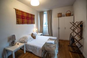 a bedroom with a bed and a table and a window at Bright airy spacious apartment in Passy