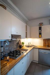 a kitchen with white cabinets and a stove top oven at Bright airy spacious apartment in Passy +8 photos