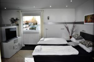 ein Wohnzimmer mit zwei Betten und einem Fernseher in der Unterkunft Villaci Business Apartments in Leimen